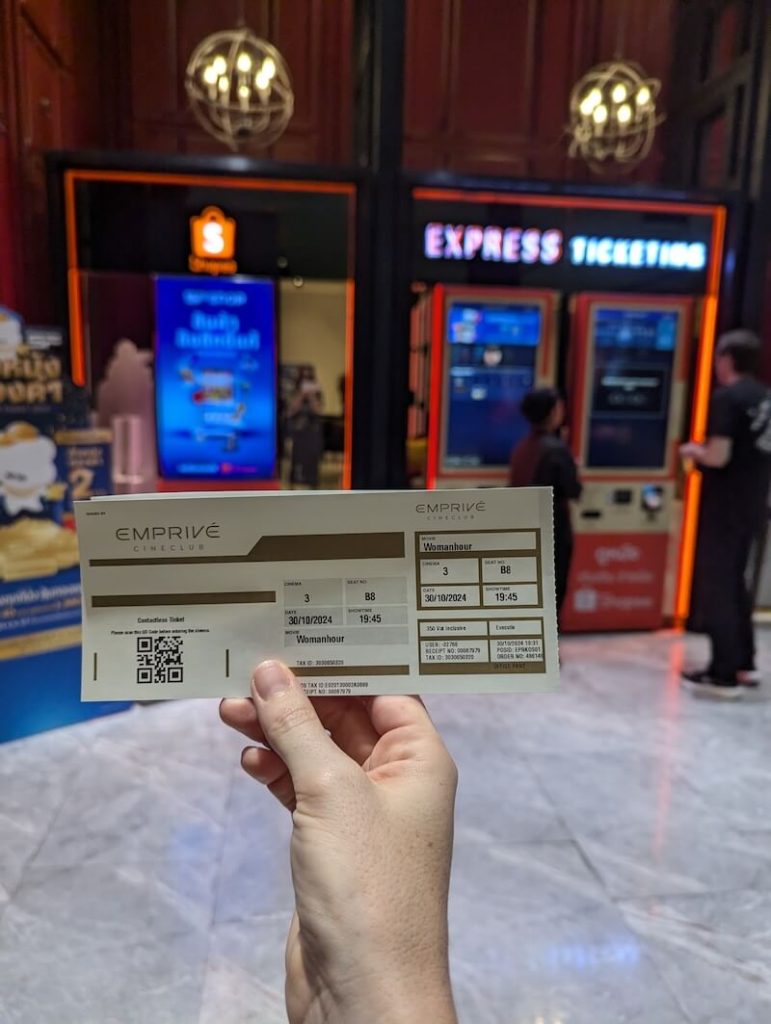 Allison Green with a movie theater ticket in her hand for the cinema called "Emprive" in Emporium Mall