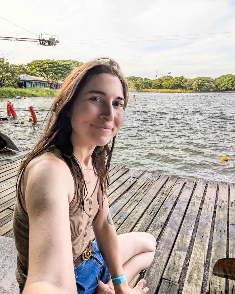 Allison Green smiling and sitting near the water at Taco Lake