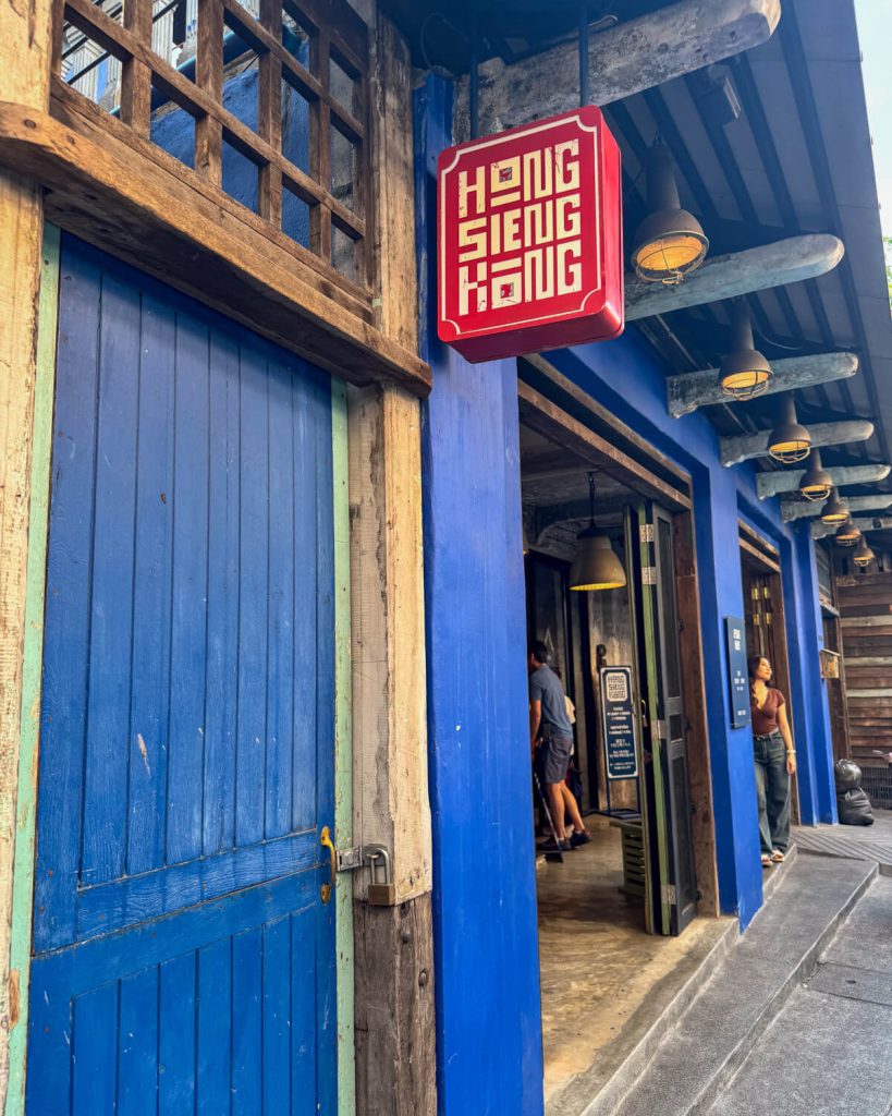 The blue doors at the entrance to Hong Sieng Kong cafe with a red sign