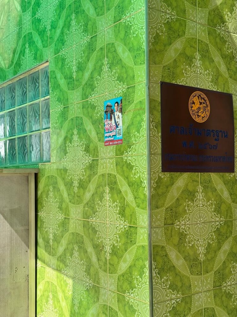Green wall with a placard that gives the name of the shrine