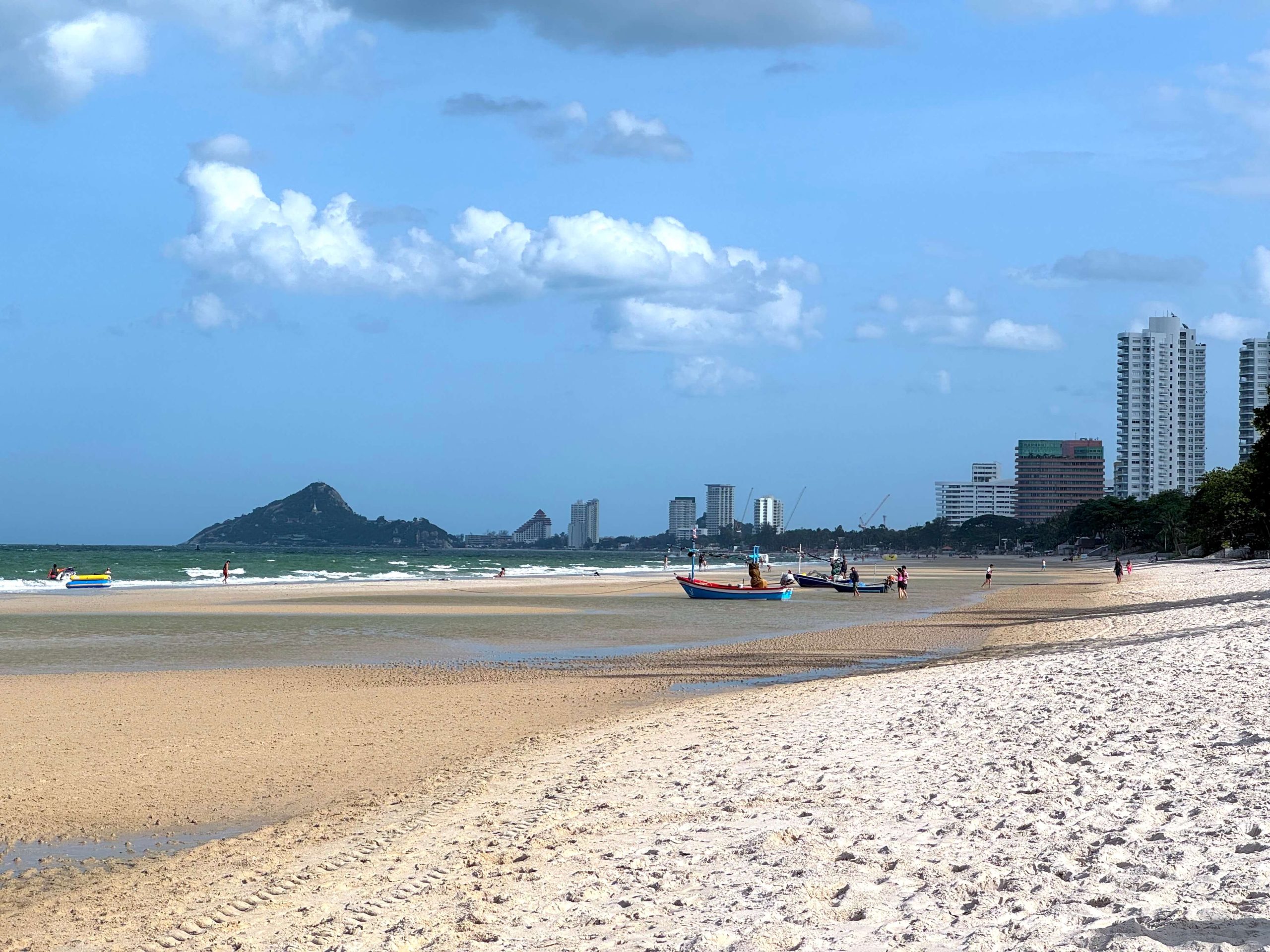 The beach of Hua Hin with mountains and buildings in the background