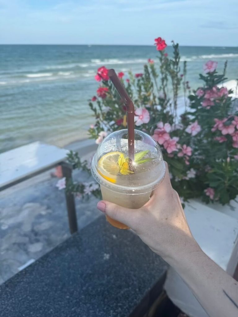 Lemon soda with flowers and sea background