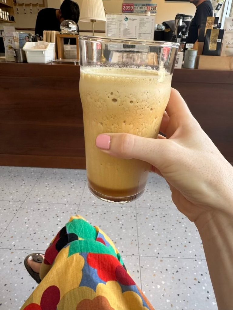 Blended coffee with lemon zest on it being held in hand